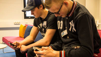 Ungdomar tittar på sina mobiltelefoner