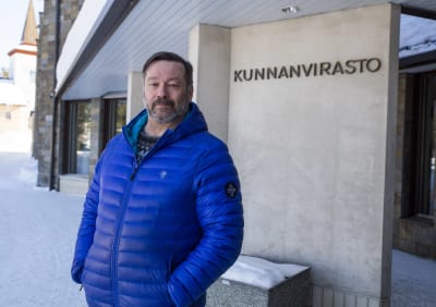 Kommundirektör Jari Rantapelkonen står utanför ämbetshuset i Sodankylä iklädd knallblå vinterjacka.