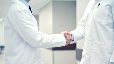 Två läkare skakar hand.