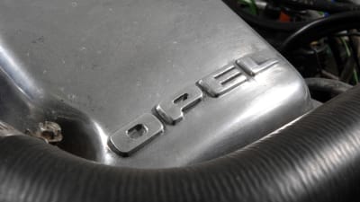 Motordel med bilmärket Opel skrivet på sig.