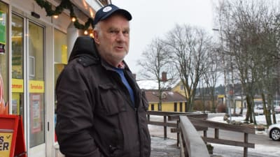 En äldre man med svart keps står utanför Sale i Dalsbruk. Slaskigt vinterväder.