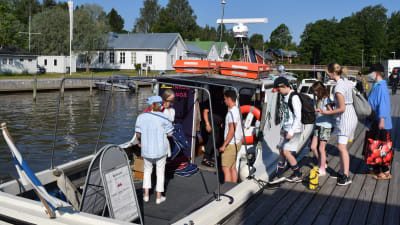 Passagerare stiger ombord på taxibåten Diana II i Ingå småbåtshamn.