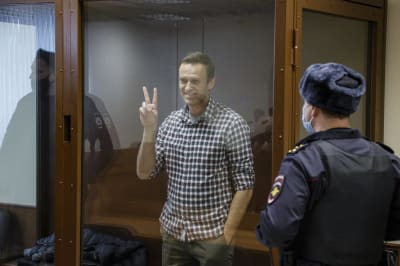 Den ryska oppositionsledaren Aleksej Navalnyj visar segertecknet i rätten