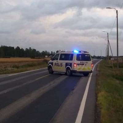 Polisbil med blåljus på på vägen till flygplatsen.