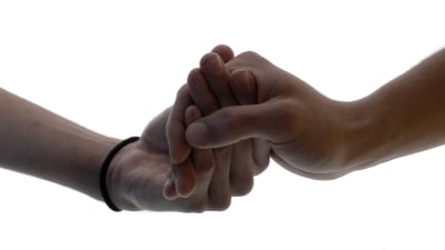 Två män håller hand.
