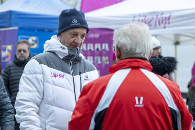 Hjallis Harkimo pratar med en person vid Rörelse Nus valtält i Lahtis. 