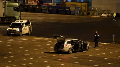 Polisbilar parkerade vid Olympiaterminalen i Helsingfors. En polis står bredvid en bil med öppna dörrar och öppen baggagelucka.