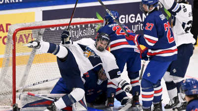 Finländsk spelare faller omkull framför USA:s mål.