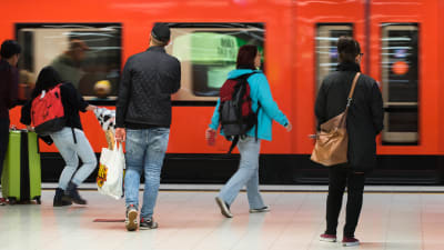 Ihmisiä astumassa metrojunaan, metro Helsingin Rautatieasema