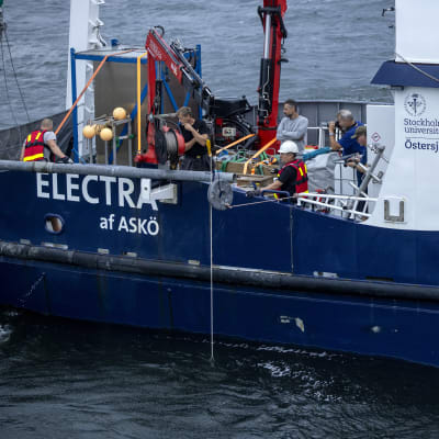 Flygfoto av det blåa forskningsfartyget Electra af Askö taget den 11 juni 2021 under den tredje dagen av den svensk-estniska dykoperationen vid MS Estonias vrak i Finska viken.