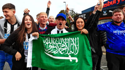 Newcastle-fans firar med en saudiarabisk flagga.