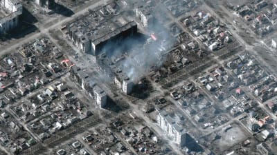 Satellitbild tagen av staden Mariupol. På bilden syns skadade och brinnande hus.