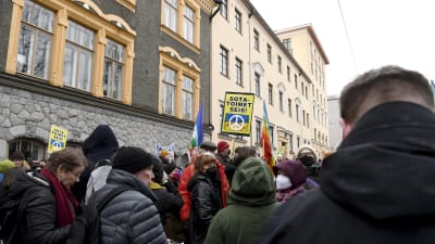 Personer protesterar utanför den ryska ambassaden i Helsingfors.