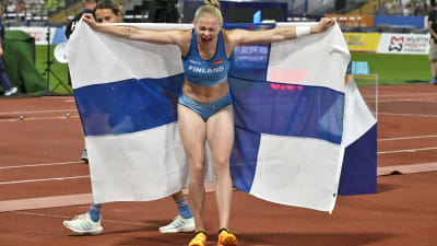 Wilma Murto jublar med Finlands flagga.