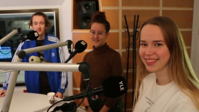 Tre ungdomar i en radiostudio med mikrofoner.