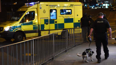 En polis går med en polishund i Manchester.