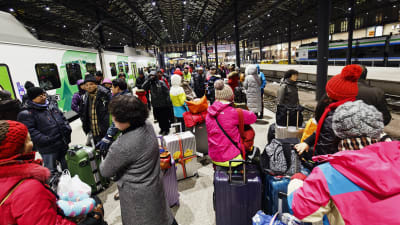 Kinesiska turister står på en perrong på Helsingfors järnvägsstation och väntar på att få stiga på tåget till Kemi, som är kraftigt försenat.