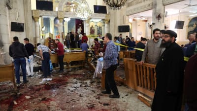 Poliser och församlingsmedlemmar betraktar förödelsen i Mar Girgis-kyrkan i Tanta. 9.4.2017