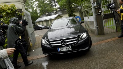 En svart bil kör ut genom grinden till statsministerns tjänstebostad Villa Bjälbo. Sannfinländarnas ordförande Jussi Halla-aho sitter i bilen.