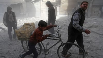 Invånare i Hamouria, östra Ghouta, tar sig fram i kvarter som nyss utsatts för en flygräd 3.12.2017.