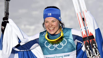 Krista Pärmäkoski med Finlands flagga.
