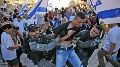 Här grips en palestinsk man som försökte bråka med de tågande judarna.