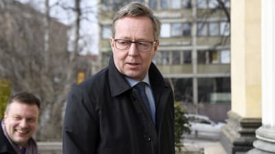 Lintilä utanför Ständerhuset i slips och svart ytterrock.