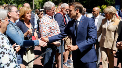 President Emmanuel Macron hälsar på folk utanför en vallokal i Le Touquet