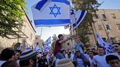Israelilaisjoukko heiluttaa Israelin lippuja.