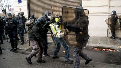 Polisen griper en demonstrant på Champs Élysées på lördag eftermiddag då hundratals andra redan gripits.