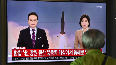 En sydkoreansk man framför en Nordkoreansk nyhetssändning var de berättar om missiltestet. 