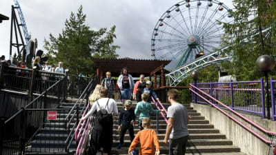 Personer går i trappor på Borgbacken, med ett pariserhjul i bakgrunden.