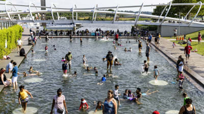 Barn och vuxna leker i vattenbassäng i Washington DC den 20 juni 2021.
