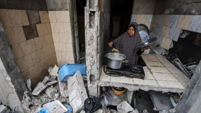 En palestinsk kvinna lagar mat i det som kvarstår av hennes hem i Gaza City efter de israeliska bombattackerna