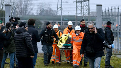 Räddningspersonal evakuerar skadade från olycksplatsen utanför Milano.