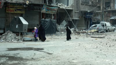 Syriska kvinnor söker skydd då staden Douma i östra Ghouta bombas 10.3.2018. 