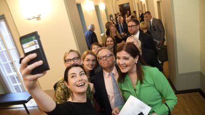 De grönas Emma Kari tar en selfie med sina riksdagskolleger.