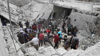 räddningsarbetare och frivilliga letar efter överlevande i ett sönderbombat hus i Kfar Khum