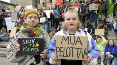 Två unga flickor med plakat i händerna med texterna "jag är rädd" och "rädda planeten"