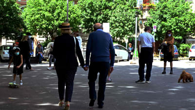 ett äldre par promenerar hand i hand i Rom
