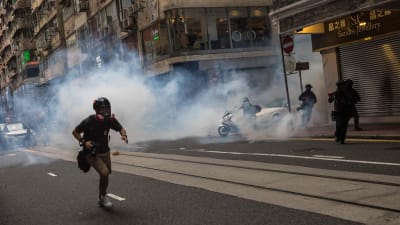 Kravallpolis avfyrar tårgas mot demonstranter i Hongkong 1.7.2020