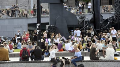 Ihmiset nauttivat kauniista kesäpäivästä Musiikkitalon edustalla Helsingissä
