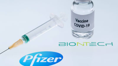 Pfizer tillverkar covid-19-vaccin. Vaccinflaska och injektionsspruta och nål.