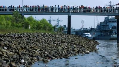 Rohingya-flyktingar skickas från Bangladesh fastland ut till en ö. 4.12.2020 väntar de på att stiga ombord på ett fartyg.