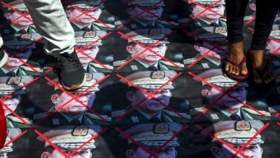 Demonstranter trampar på bilder av militärregimen i Myanmar
