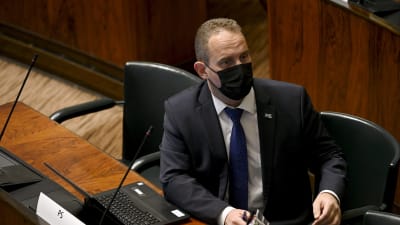 Jani Mäkelä med munskydd i riksdagen.