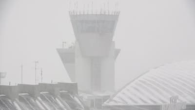 Flygledartornet bakom yrande snö på Helsingfors-Vanda flygplats