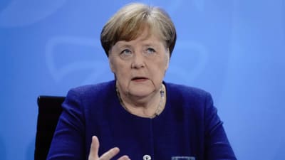 Merkel sitter och gestikulerar med händerna.