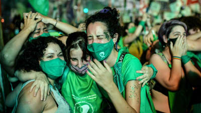 Människor klädda i gröna kläder firar utanför senaten i Argentina efter att abort legaliserats i landet.