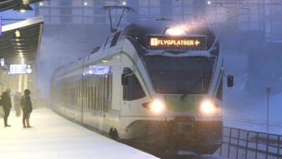 Ett närtåg i snöyra. Tåget är på väg till Helsingfors-Vanda flygplats.